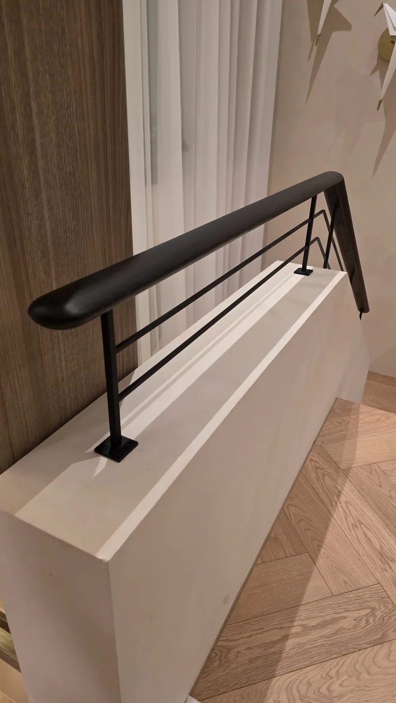 Black steel railing with a CNC-cut oak top rail
