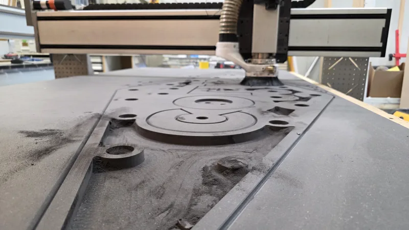 CNC router cutting letters from a dark panel